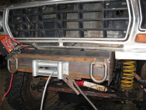 1978 Ford Bronco - A close-up view of a custom-built front bumper a winch and recovery D-rings, attached to a vehicle.