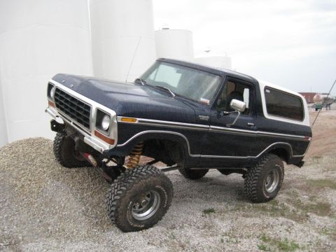 1978 Ford Bronco - Modified 1978 Ford Bronco with off-road tires and suspension, positioned on a gravel pile.