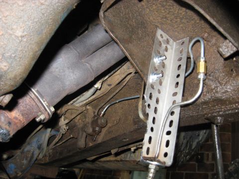 1978 Ford Bronco - Close-up of vehicle undercarriage showing exhaust system and brake lines, with a metal bracket.