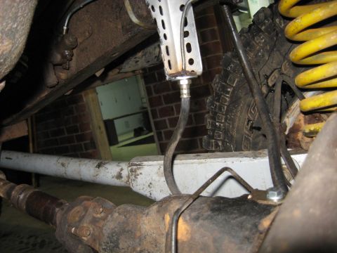 1978 Ford Bronco - Undercarriage view showing the rear axle, brake lines, and suspension components of a vehicle.