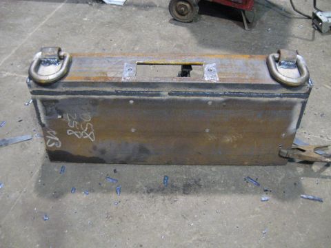 1978 Ford Bronco - A welded metal box with D-rings and visible markings sits on a concrete floor.