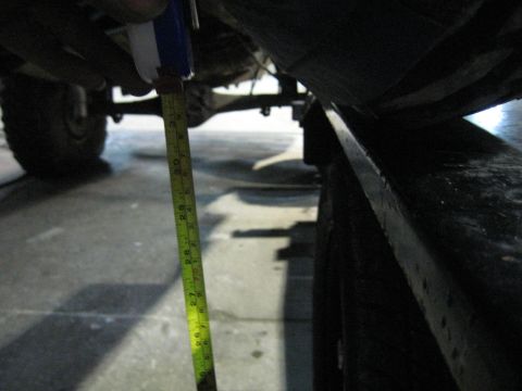 1978 Ford Bronco - A measuring tape is used to gauge the height of a vehicle's undercarriage.