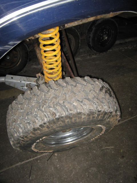 1978 Ford Bronco - Close-up of a vehicle's suspension system and tire, with other wheels visible.