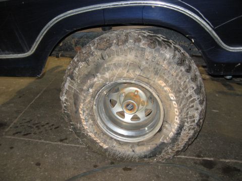1978 Ford Bronco - Close-up of a BFGoodrich Mud-Terrain T/A tire mounted on a vehicle's wheel, with the dark blue fender visible above.