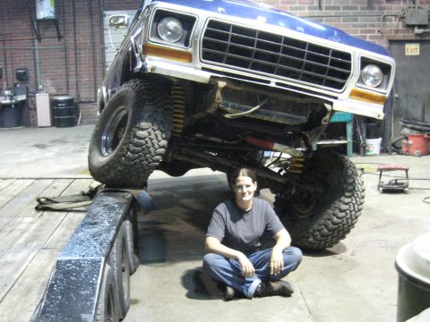 1978 Ford Bronco - A blue 1978 Ford Bronco is shown on a ramp, with a person sitting beneath it in a garage setting.