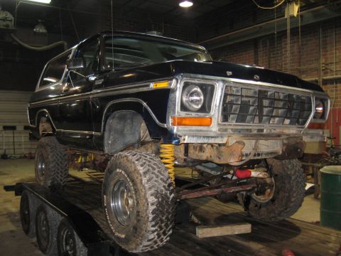 1978 Ford Bronco - A black 1978 Ford Bronco is shown on a trailer, lifted with large off-road tires.
