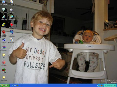 1986 Ford Bronco - A young boy proudly displays his t-shirt while a baby sits in a high chair behind him.