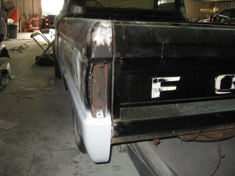 1966 Ford F-100 - Rear of a 1966 Ford F-100 undergoing bodywork, showing primer on the quarter panel and tailgate.