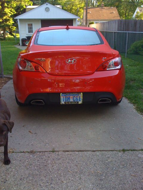 2010 Hyundai Genesis - A red 2010 Hyundai Genesis coupe is parked in a driveway, viewed from the rear.