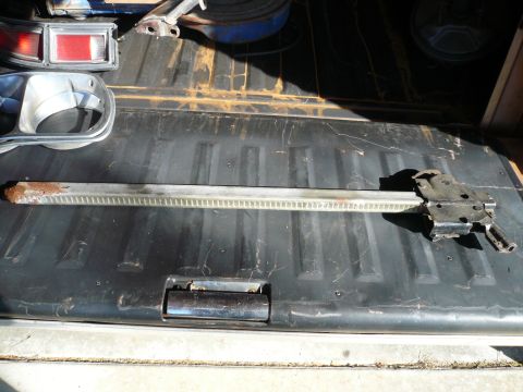 1975 Ford Ranchero - A vehicle jack and a taillight assembly are laid out in the bed of a truck.