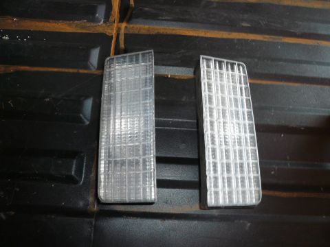 1975 Ford Ranchero - A pair of clear plastic marker lights are shown against a dark, textured background.