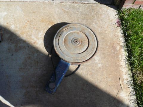 1975 Ford Ranchero - Air cleaner assembly resting on a concrete surface next to grass.