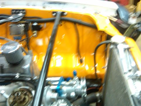 1978 Ford Mustang II - Engine bay components are visible, including an air filter and radiator, against a bright yellow firewall.