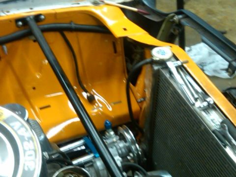 1978 Ford Mustang II - The engine bay of a vehicle is shown, the radiator and various engine parts.