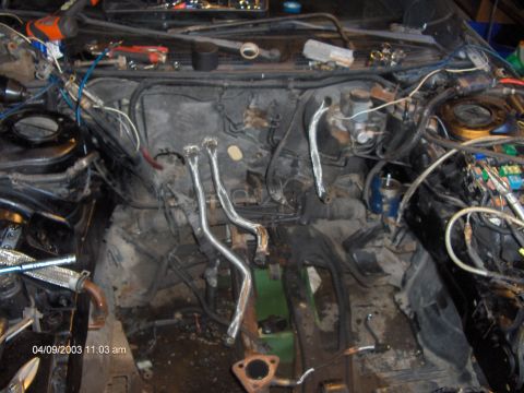 1993 Ford Probe - The engine bay is cluttered with tools and wiring, suggesting a project in progress.