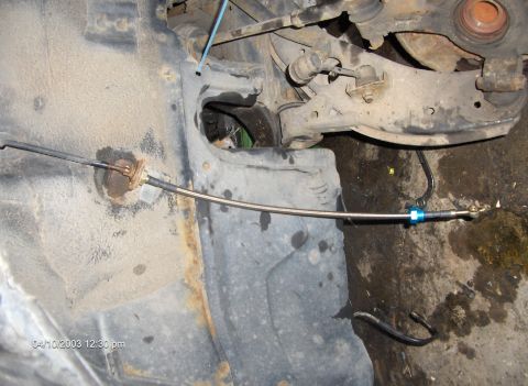 1993 Ford Probe - Close-up of a car's undercarriage showing a brake line and suspension components.