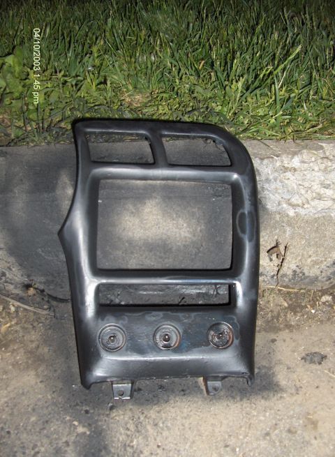 1993 Ford Probe - A black dashboard trim piece with three circular indentations and two rectangular openings is shown.