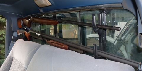 2006 Ford E350 - Two long guns are secured in a rack behind the rear seats of a vehicle.