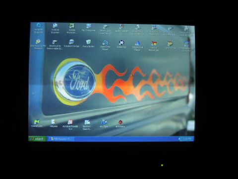 1981 Ford Bronco - A computer screen displays a desktop background a Ford emblem and flame graphics on a vehicle's side.