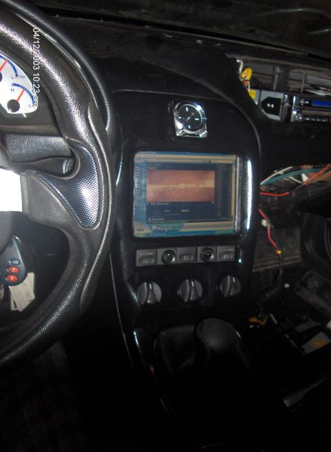 1993 Ford Probe - The interior of a car shows a modified dashboard with an aftermarket screen and exposed wiring.