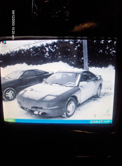 1993 Ford Probe - A 1993 Ford Probe is parked in the snow, with another vehicle visible behind it.
