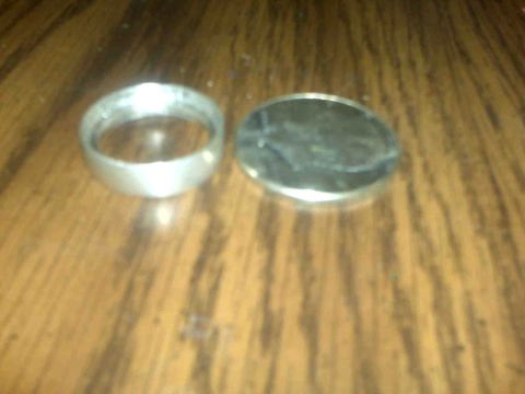 1995 Ford Bronco - A coin and a ring are placed on a wooden table.