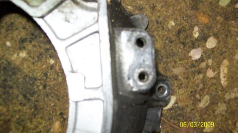 1973 Ford Ranchero - A close-up view of a metal component, possibly from a vehicle's drivetrain, is shown against a background of dirt and leaves.