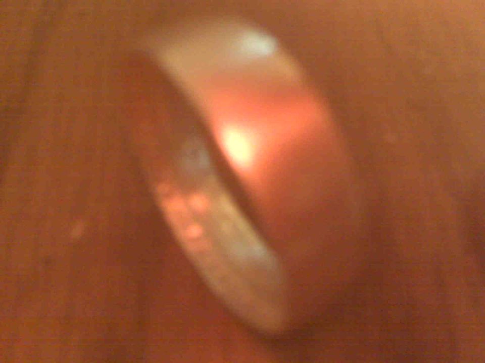 Close-up of a coin ring with a red glow reflecting on its surface