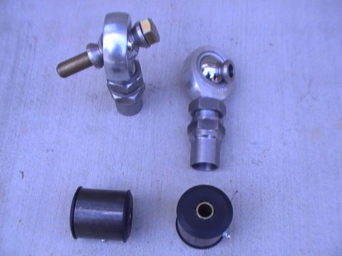 1997 Ford Ranger - A collection of automotive suspension components, including rod end bearings and rubber bushings, are laid out on a textured surface.