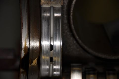 1996 Ford Bronco - A close-up view of a worn engine bearing, likely from a 5.8L engine, showing signs of oil residue and wear.