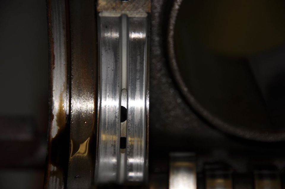 Close-up of a worn engine bearing with oil residue