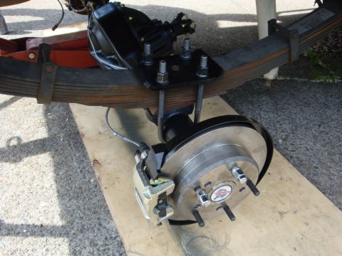 1989 Ford Bronco - Close-up of a vehicle's rear axle assembly, showing leaf springs, brake components, and a differential housing.