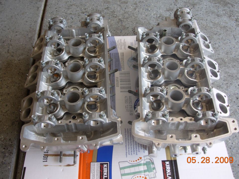 Pair of aluminum engine cylinder heads on a box with a date stamp