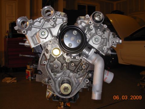 1995 Ford Taurus - Close-up view of a V8 engine, with a white car visible in the background.