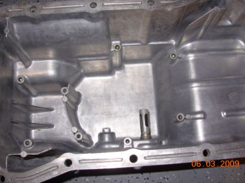 1995 Ford Taurus - This is a close-up view of an oil pan, likely from an engine, showing its internal structure and mounting points.