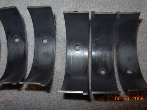 1995 Ford Taurus - Used engine bearings shown on a carpeted surface, indicating wear.