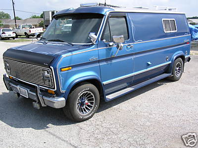 1978 Ford E150 - This blue 1978 Ford E150 van is shown from a 3/4 front angle, custom wheels and a hood protector.