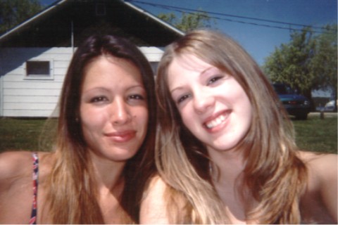 1990 Ford Taurus - A dark blue sedan is visible in the background behind two women posing for a photo.