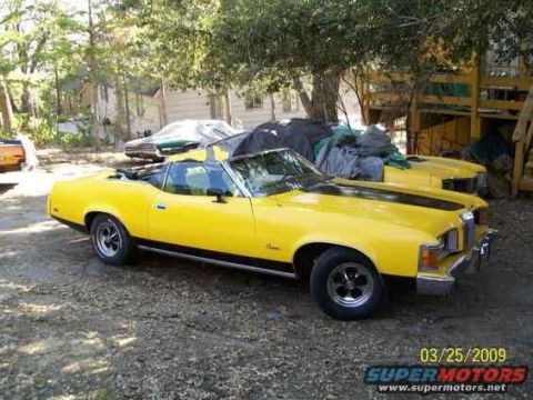 1973 Mercury Cougar - Yellow 1973 Mercury Cougar convertible parked in a yard with another vehicle behind it.