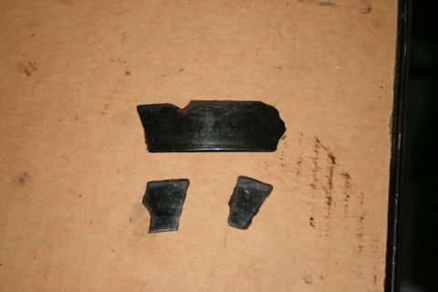 1990 Chevrolet Suburban - Several pieces of a broken transmission are scattered on a brown surface.