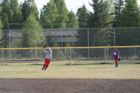 1990 Chevrolet Suburban - A baseball player leaps to catch a ball during a game, with another player in the background.