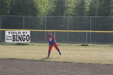 1990 Chevrolet Suburban - A young athlete stands ready on a baseball field with a banner in the background advertising a bingo event.