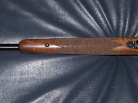 1991 Ford Bronco - Close-up view of a wooden rifle stock, showing the checkering pattern and the bolt mechanism.