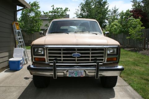 1984 Ford Bronco - This tan Ford Bronco is parked in a driveway with a ladder and cooler nearby.