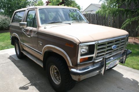 1984 Ford Bronco - This two-tone brown 1984 Ford Bronco is parked on a concrete driveway.