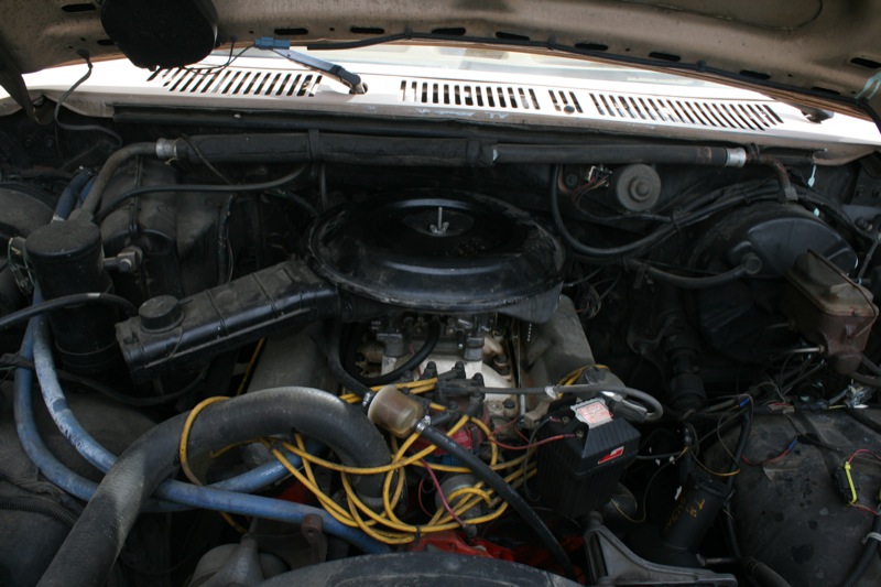 Engine bay with carburetor and yellow spark plug wires