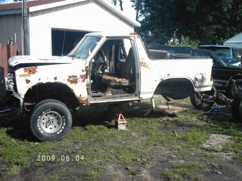 1986 Ford Bronco - This 1986 Ford Bronco is in a state of disrepair, missing its doors and hood, and is elevated on jack stands.