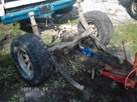 1986 Ford Bronco - Rear axle and suspension components are visible, with jacks supporting the vehicle.
