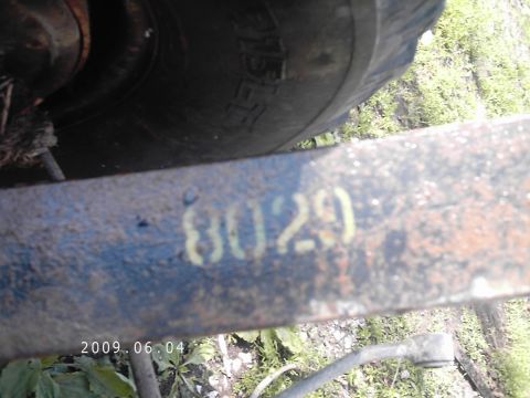1986 Ford Bronco - Close-up of a vehicle frame shows stenciled numbers and a tire, with a date stamp of 2009.06.04.