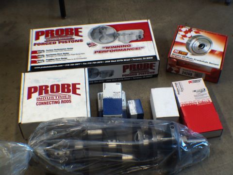 1996 Ford Bronco - Various engine components, including pistons, connecting rods, and a crankshaft, are laid out on a floor.